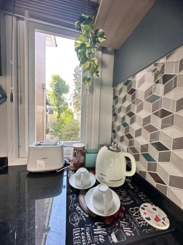 a kitchen counter with a tea kettle and plates on it at Sirihouse at Supalai Bella Thalang Phuket in Phuket