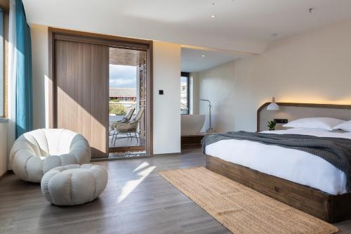 a bedroom with a large bed and a balcony at 清舍雪山观景设计师民宿 in Lijiang