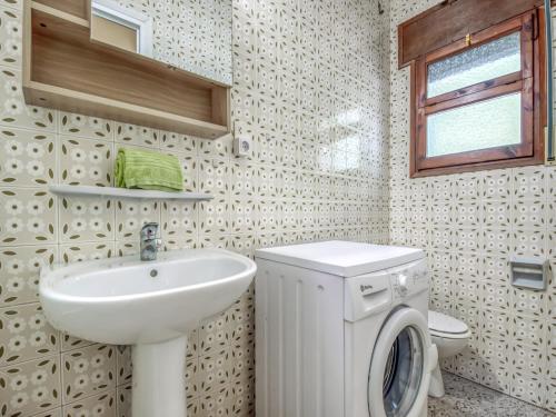 a bathroom with a sink and a washing machine at Beachfront Apartment in Platja Almadrava in Montjoys