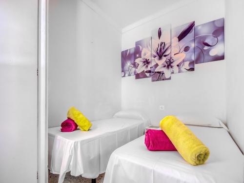 two white tables with yellow and pink pillows on them at Beachfront Apartment in Platja Almadrava in Montjoys