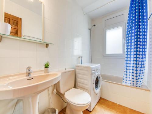 ein Badezimmer mit Toilette, Waschbecken und Waschmaschine in der Unterkunft Apartment in Rosas near Cap de Creus in Montjoys
