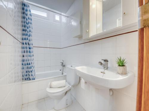 a white bathroom with a toilet and a sink at Apartment in Roses near beach in Montjoys
