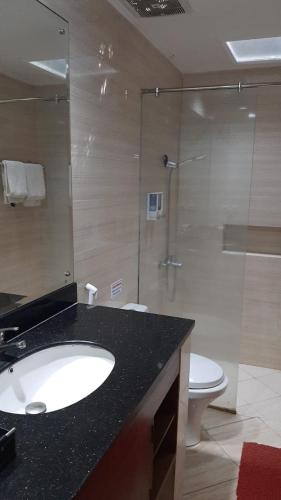 a bathroom with a sink and a shower with a toilet at Griya Wijilan Syariah in Yogyakarta