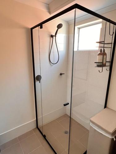 a shower with a glass door in a bathroom at The Stanley in Henley Brook