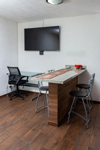 a conference room with chairs and a desk with a flat screen tv at Departamento cerca de Zoológico y Estadio Jalisco in Guadalajara