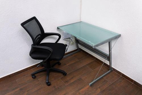 a desk with a chair and a glass table at Departamento cerca de Zoológico y Estadio Jalisco in Guadalajara