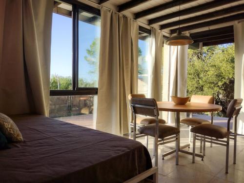 a bedroom with a bed and a table and chairs at Refugio Verde en Nono, Córdoba in Nono