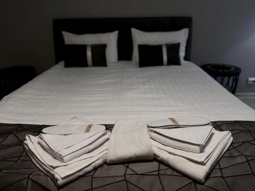 a bed with white sheets and towels on it at Garsonierele Scandinav in Predeal