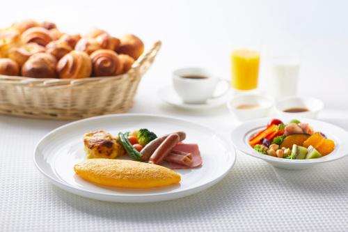 a table with plates of food and a basket of bread at The Royal Park Hotel Iconic Kyoto in Kyoto