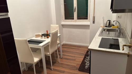 a kitchen with a table with chairs and a sink at Gianicolo House in Rome