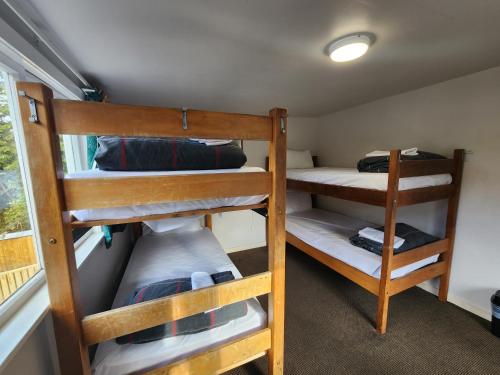 two bunk beds in a room with a window at Pinewood Queenstown in Queenstown