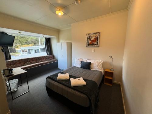 a hotel room with a bed and a window at Pinewood Queenstown in Queenstown