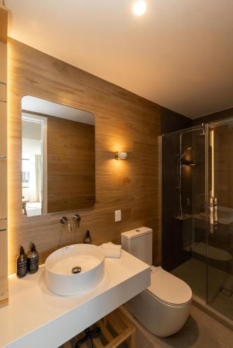 a bathroom with a sink and a toilet and a mirror at Maxim Hotel - Auckland in Auckland