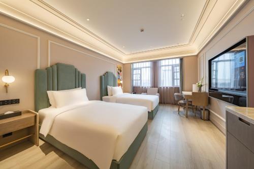 a hotel room with two beds and a television at Meilun Hotel Shanghai International Tourist Resort in Shanghai