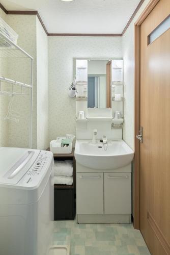 a white bathroom with a sink and a mirror at Westeria201 ペット子供歓迎JR春日井駅より徒歩3分長期滞在に最適 in Kasugai
