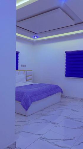 a bedroom with a bed with a purple blanket at Urban Shortlet Abuja in Abuja