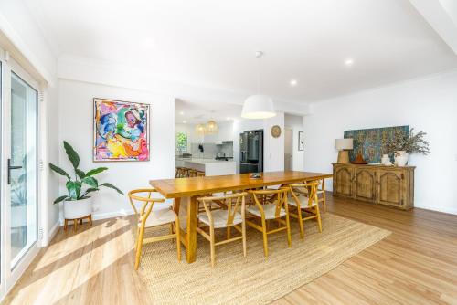 a kitchen and dining room with a wooden table and chairs at Fully renovated and stylish home in Narrabundah - Hosted by Canstay in Narrabundah