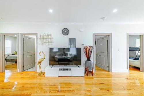 a living room with a flat screen tv on a stand at 82 - 3BR Boston - Stylish Stay near MBTA in Boston
