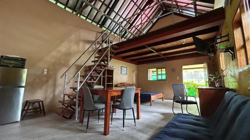 a living room with a table and chairs and a staircase at Strandhaus auf Sibuyan Island nahe Cresta de Gallo - Marevic's Guesthouse 2 in San Fernando