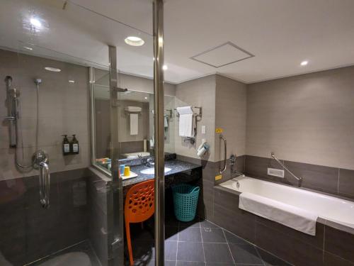 a bathroom with a tub and a sink and a shower at Howard Beach Resort Kenting in Kenting