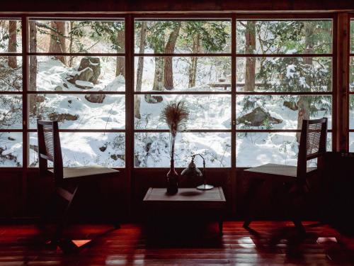 une chambre avec deux tables et une fenêtre avec de la neige dans l'établissement La Terra Resort, à Seba