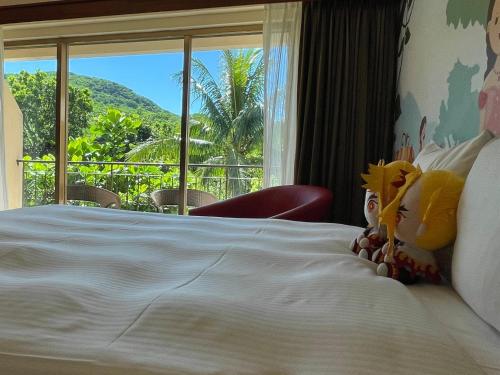 a bedroom with a white bed with a large window at Howard Beach Resort Kenting in Kenting