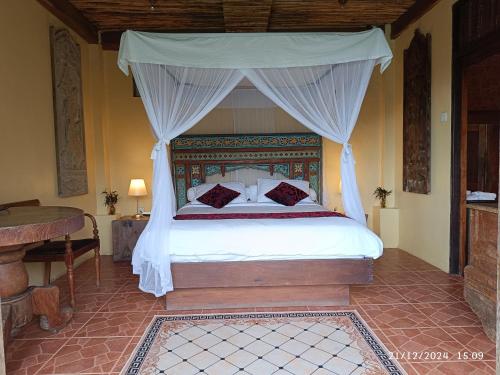 a bedroom with a bed with a canopy at DWan Tea Mountain Side in Jatiluwih