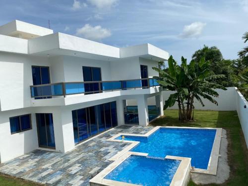 une maison blanche avec une piscine devant dans l'établissement VillaGuerra-Piscina-Billar-BBQ-WiFi-Cozy-3Br-5Bds-7Pax, à Guerra