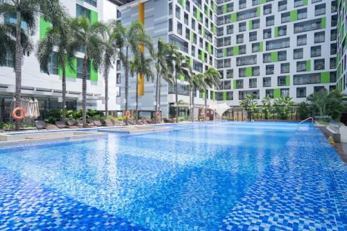 a large swimming pool with palm trees and buildings at APARTMENT AIRPORT TAN SON NHAT - free Pool & Gym in Ho Chi Minh City