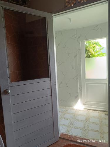 a door leading into a room with a window at DWan Tea Mountain Side in Jatiluwih