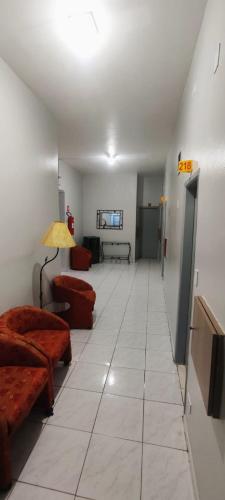 a living room with two couches and a room with a hallway at Hotel Lado Leste in Sao Paulo