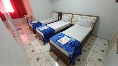 two beds in a room with blue and white at Hotel Lado Leste in Sao Paulo