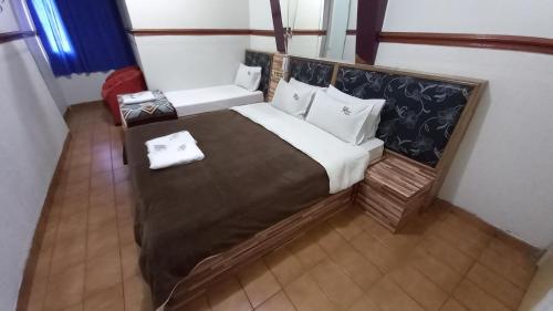 a bedroom with a large bed with a wooden headboard at Hotel Lado Leste in Sao Paulo