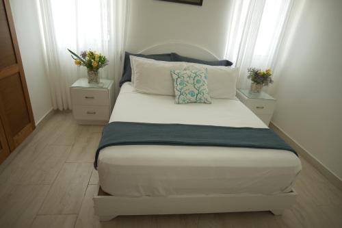 - une chambre avec un lit, 2 tables de chevet et 2 fenêtres dans l'établissement VillaGuerra-Piscina-Billar-BBQ-WiFi-Cozy-3Br-5Bds-7Pax, à Guerra