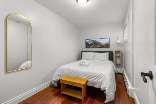 een witte slaapkamer met een bed en een tafel bij Forest House 1 Bdrm Qv Lake View Parking in St. John's