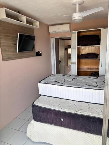 a room with two mattresses and a tv on the wall at Monte Castelo Flat 08B in Sairé