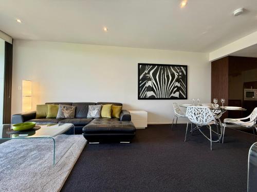 堪培拉Manhattan Luxe Views L14 Pool Spa Gym 1BR 1 Bath 1 Secure Parking Central City的带沙发和桌子的客厅