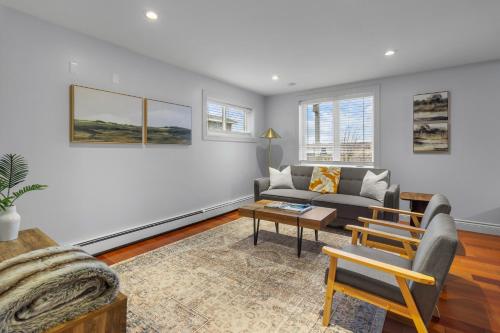 een woonkamer met een bank en een tafel bij Forest House 1 Bdrm Qv Lake View Parking in St. John's