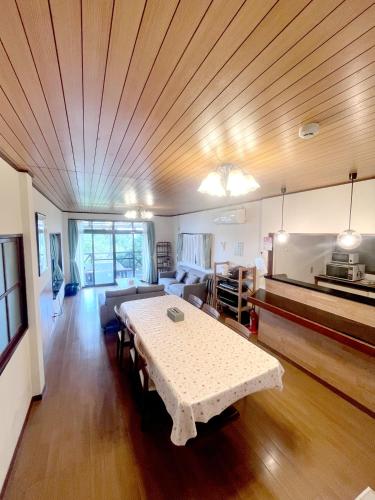 a living room with a table and a couch at 熱海温泉自然郷の眺望の貸し切り in Atami