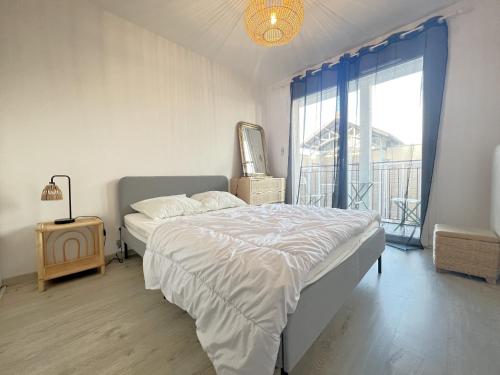une chambre avec un lit et une grande fenêtre dans l'établissement Appartement centre Arcachon, proche plage, 6 couchages, balcon, parking, Wifi inclus - FR-1-474-258, à Arcachon