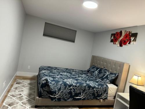 a bedroom with a bed with a blue comforter at Live-more cozy newly built one-bedroom apartment in Moncton