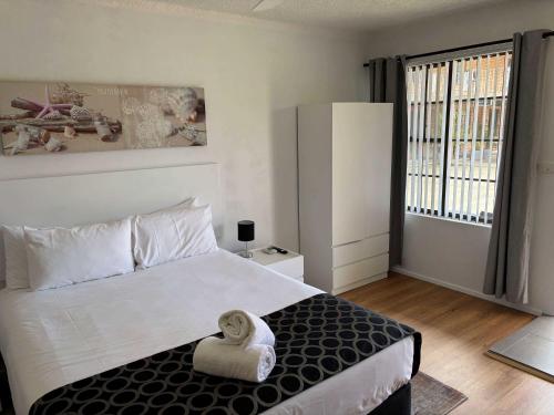 a bedroom with a large bed and a large window at Bella Villa Motor Inn in Forster
