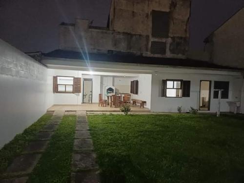 a white house with a backyard at night at Casa de Praia aconchego in Guaratuba