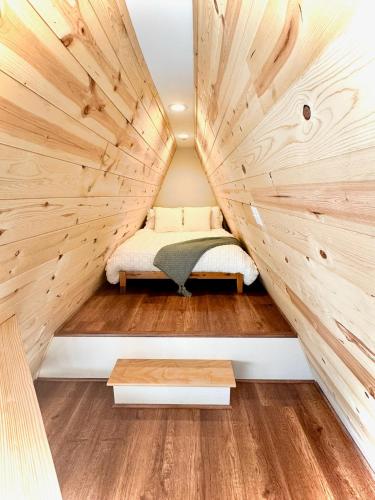 a small bedroom in a tiny house with wood paneling at The Charlotte A-Frame cabin with mountain views in Wilsonville
