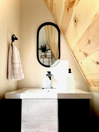 a bathroom with a sink and a mirror at The Charlotte A-Frame cabin with mountain views in Wilsonville