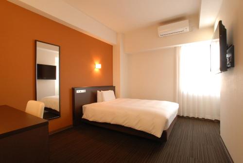 a hotel room with a bed and a mirror at AB Hotel Komaki in Komaki