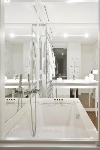 a white bathroom with a tub and a sink at Magna Pars l'Hotel à Parfum, Small Luxury Hotels of the World in Milan