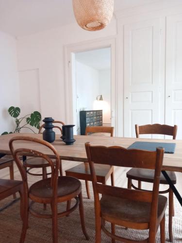 a dining room with a wooden table and chairs at Appartement et jardin près du lac in Nidau