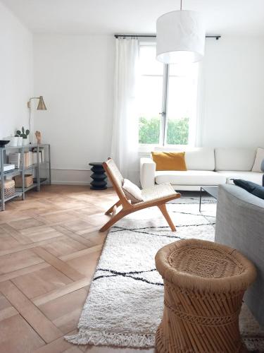 a living room with a couch and a chair at Appartement et jardin près du lac in Nidau