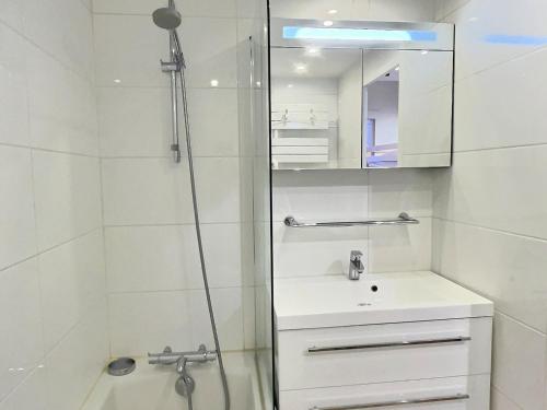 une salle de bain avec une douche, un lavabo et un miroir dans l'établissement Studio pour 4 personnes à Val-d'Isère, balcon exposé sud - FR-1-411-882, à Val dʼIsère